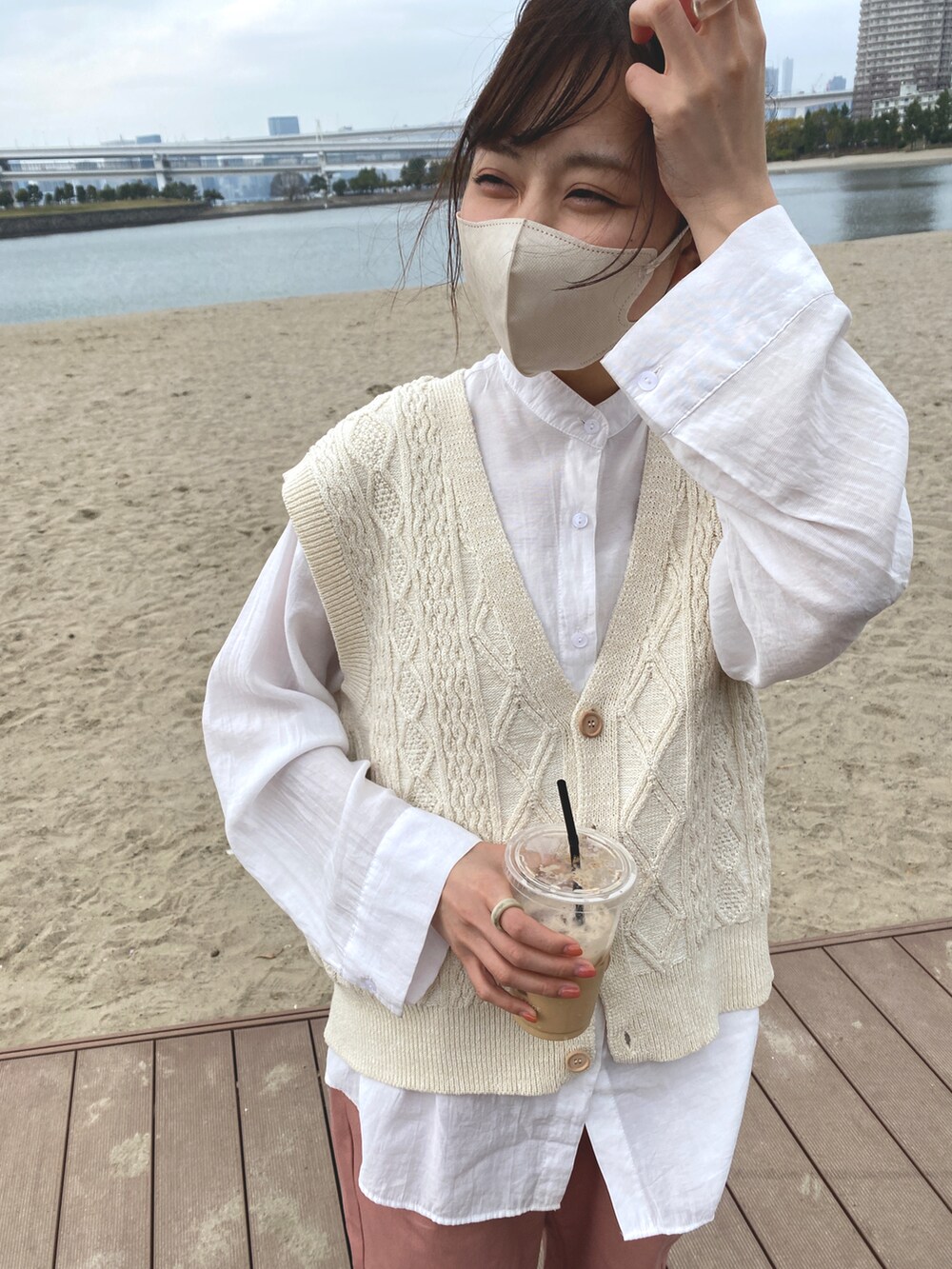 ピンク系のチノパンツ、その他のスニーカー、ホワイト系のベストを着用したレディースの春コーディネートの2枚目の写真