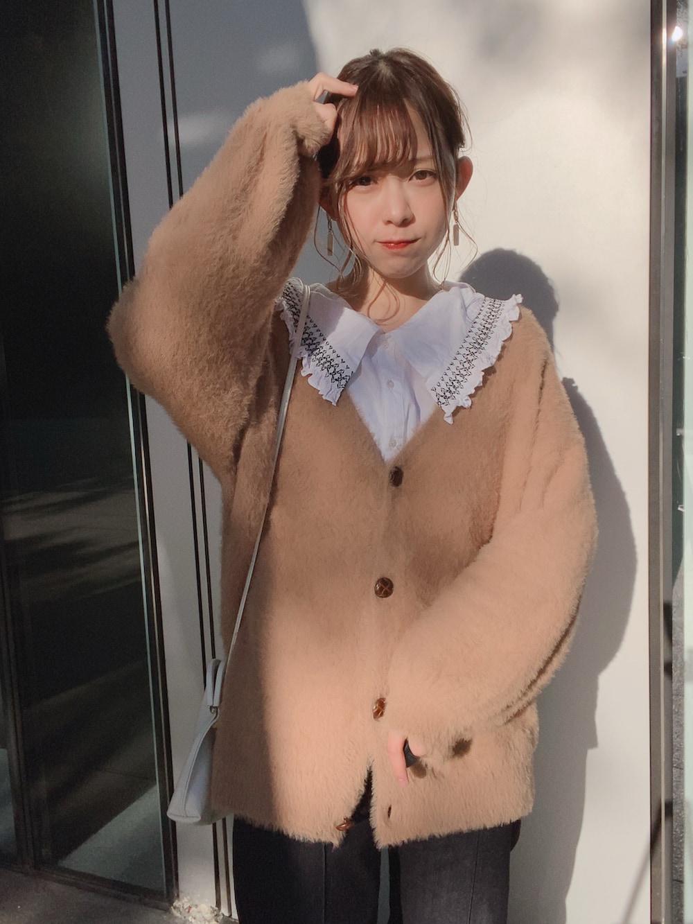 ブルー系のデニムパンツ、ホワイト系のブーツ、ベージュ系のカーディガン/ボレロを着用したレディースの秋コーディネートの2枚目の写真