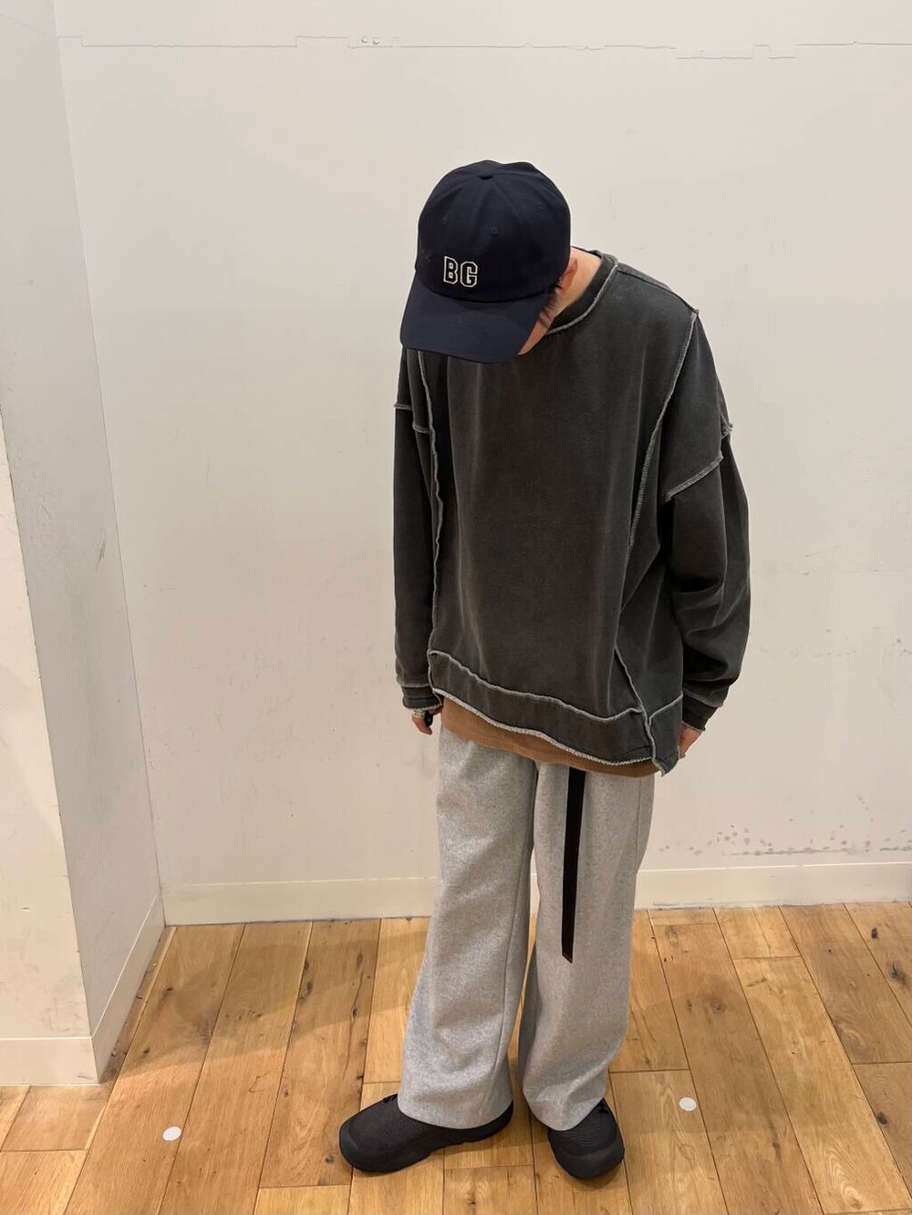 グレー系のその他パンツ、グレー系のスウェット、ブルー系のキャップを着用したメンズの冬コーディネートの2枚目の写真