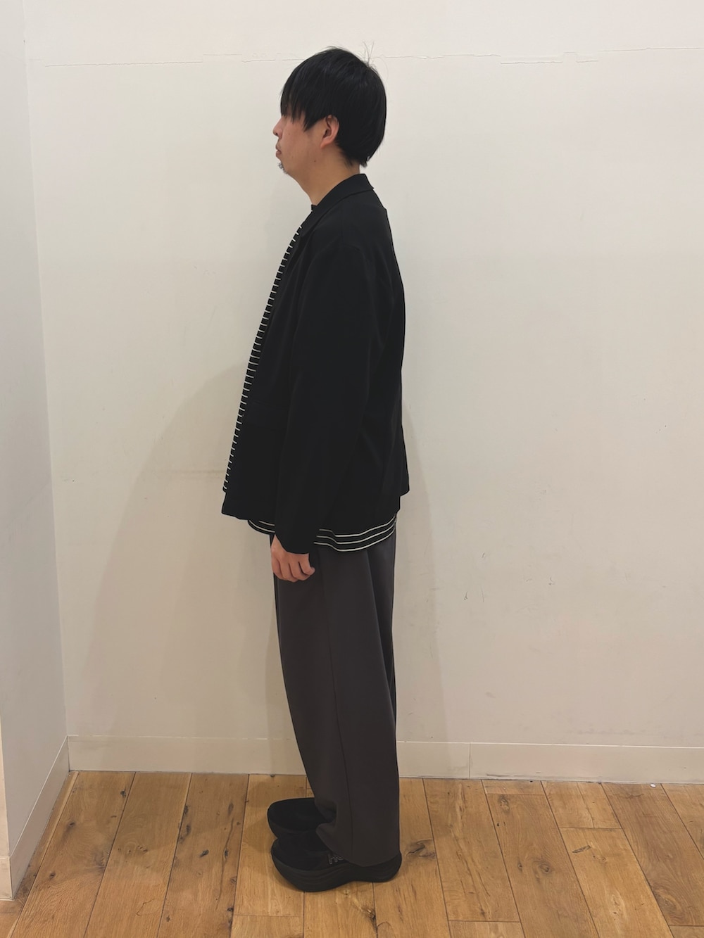 ブラック系のテーラードジャケット、ブラック系のTシャツ/カットソー、グレー系のその他パンツを着用したメンズの春コーディネートの2枚目の写真