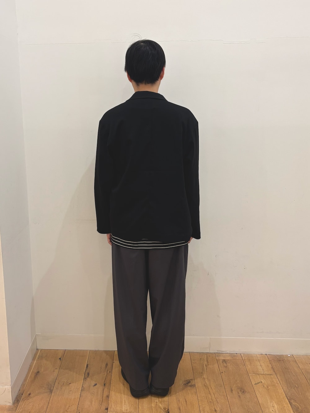 ブラック系のテーラードジャケット、ブラック系のTシャツ/カットソー、グレー系のその他パンツを着用したメンズの春コーディネートの3枚目の写真