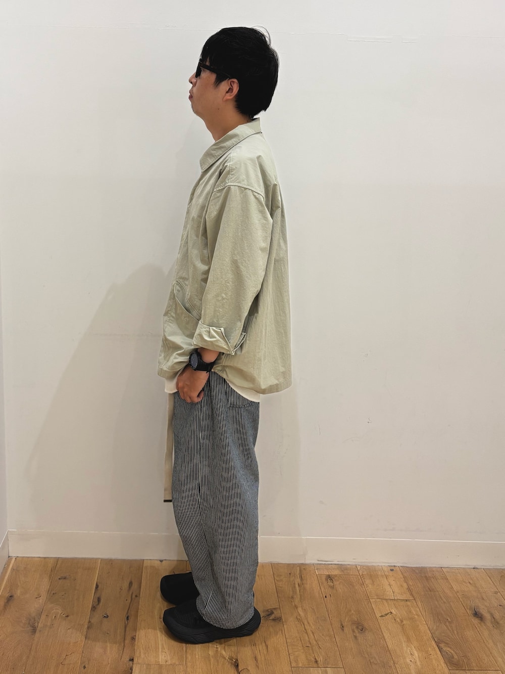 ベージュ系のナイロンジャケット、ブルー系のその他パンツ、ブラウン系のメガネを着用したメンズの秋コーディネートの2枚目の写真