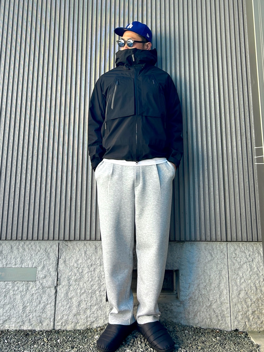 ブラック系のマウンテンパーカー、ホワイト系のTシャツ/カットソー、グレー系のスウェットパンツを着用したメンズの春コーディネートの2枚目の写真
