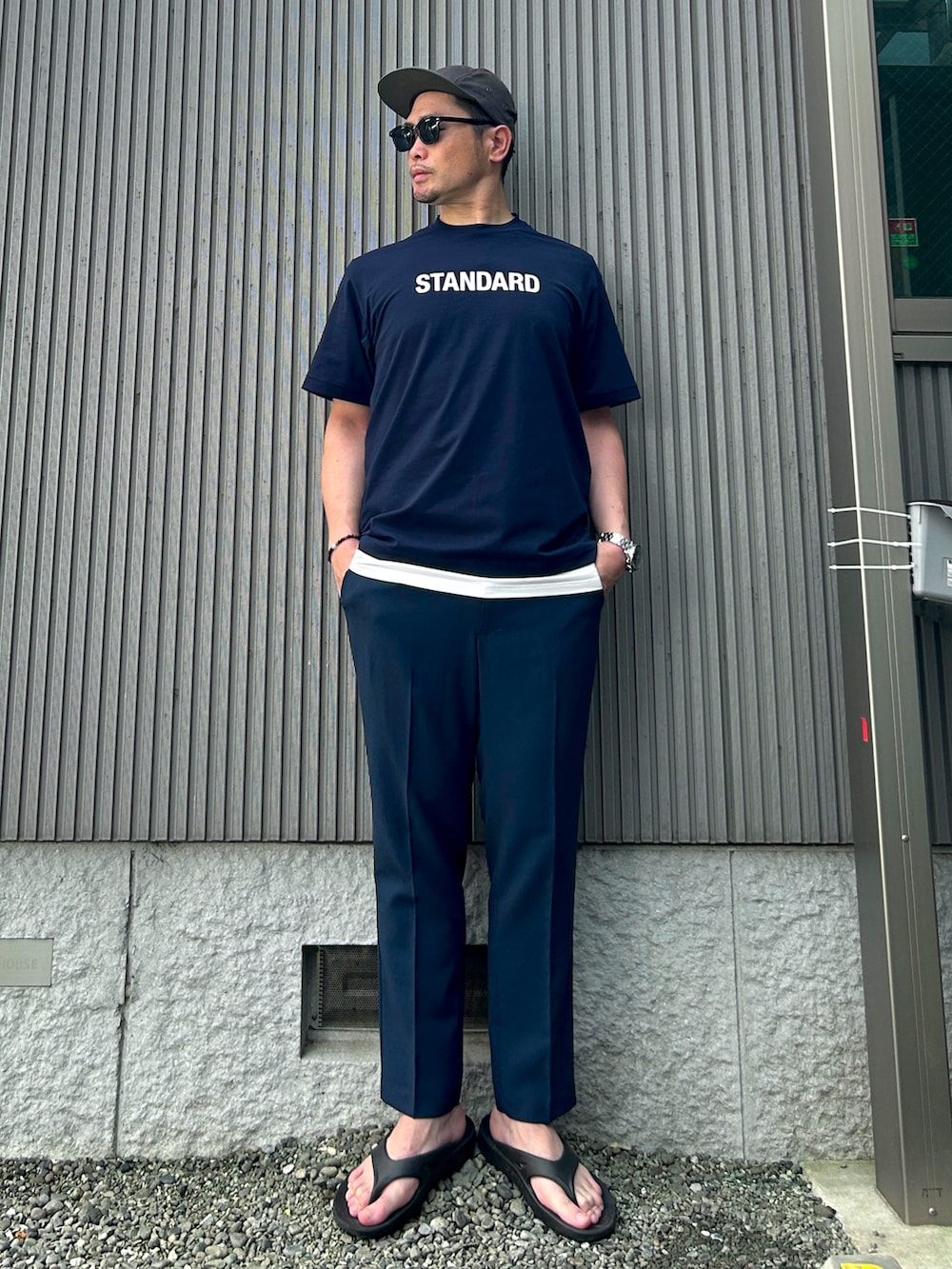 ブルー系のTシャツ/カットソー、ブルー系のスラックス、ブラック系のサンダルを着用したメンズの夏コーディネートの3枚目の写真