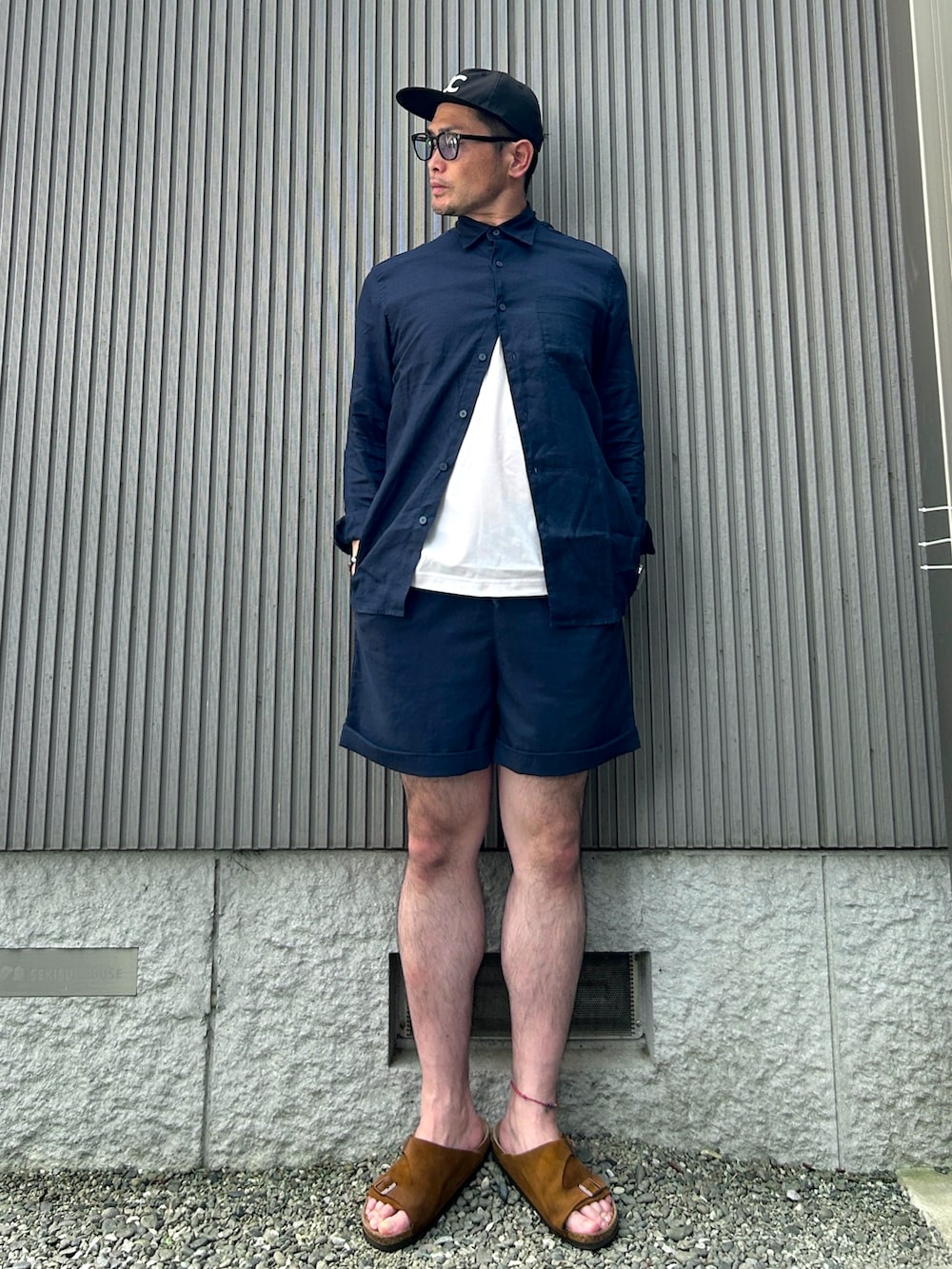 ブラウン系のサンダル、ブルー系のシャツ/ブラウス、ホワイト系のTシャツ/カットソーを着用したメンズの夏コーディネートの2枚目の写真