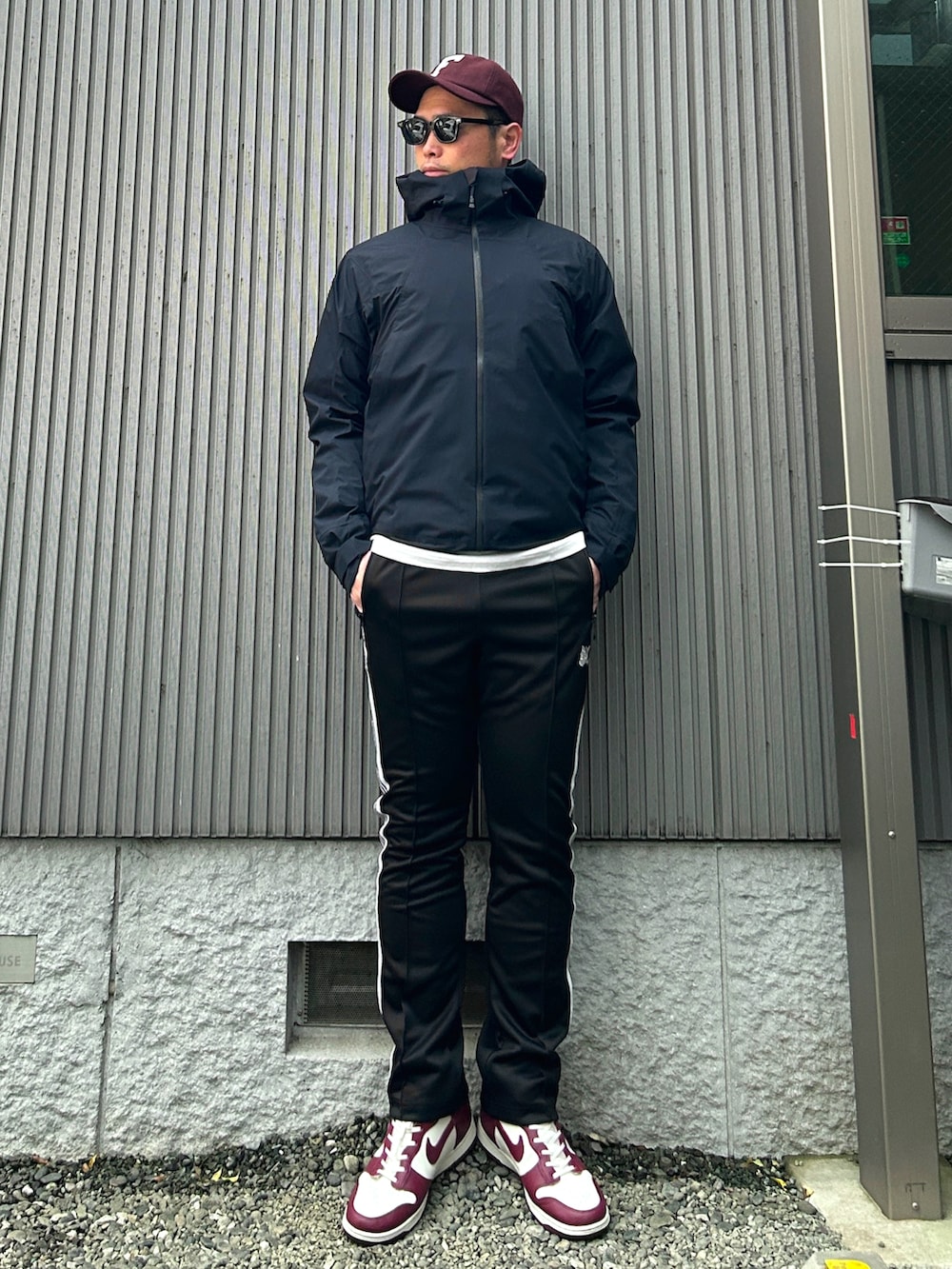 ブラック系のマウンテンパーカー、ブラック系のダウンジャケット/コート、ホワイト系のTシャツ/カットソーを着用したメンズの春コーディネートの2枚目の写真