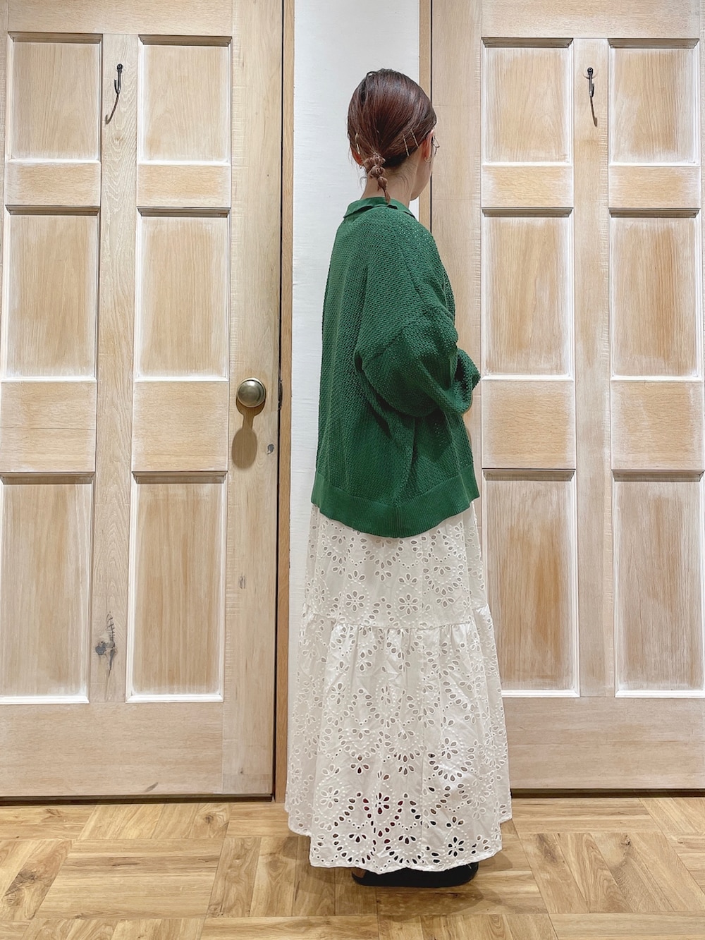 グリーン系のカーディガン/ボレロ、ホワイト系のTシャツ/カットソー、ホワイト系のスカートを着用したレディースの春コーディネートの2枚目の写真