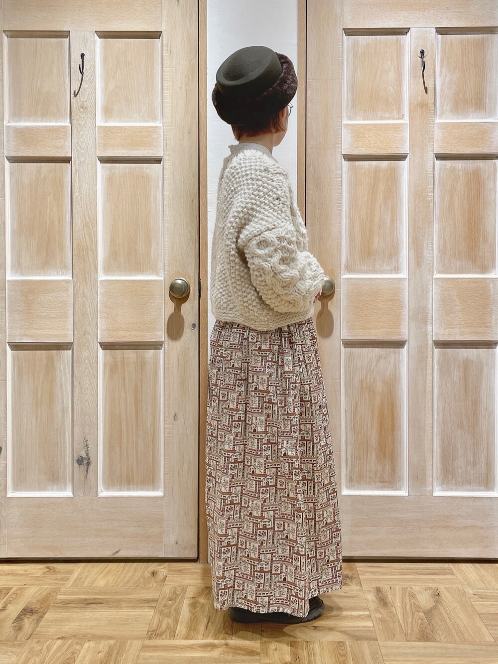 ホワイト系のニット/セーター、レッド系のスカート、ブラウン系のハットを着用したレディースの冬コーディネートの2枚目の写真