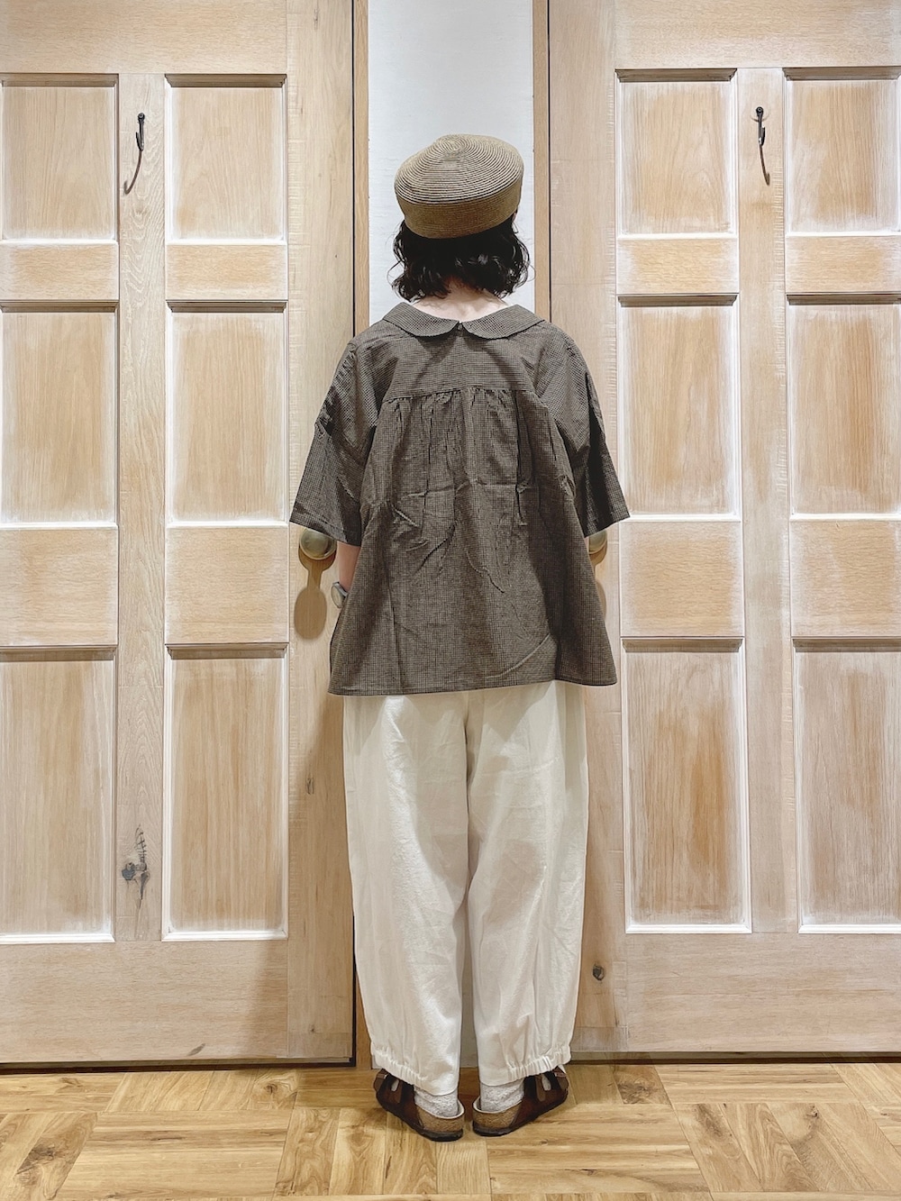 ベージュ系のTシャツ/カットソー、ホワイト系のその他パンツ、ブラウン系のサンダルを着用したレディースの夏コーディネートの3枚目の写真