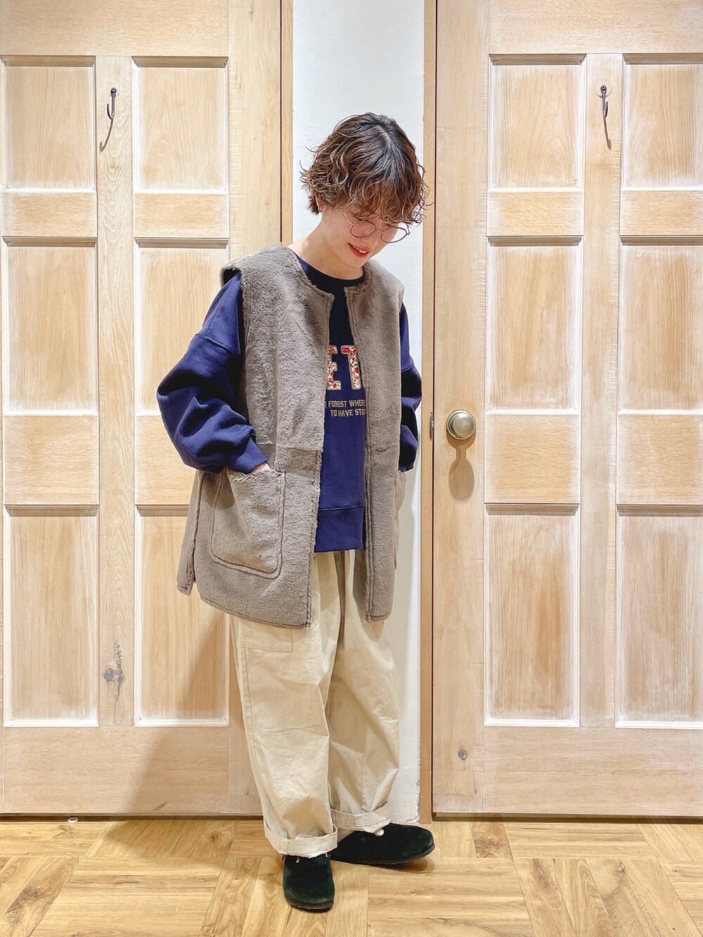 グレー系のベスト、ブラック系のスウェット、ベージュ系のカーゴパンツを着用したレディースの秋コーディネートの2枚目の写真