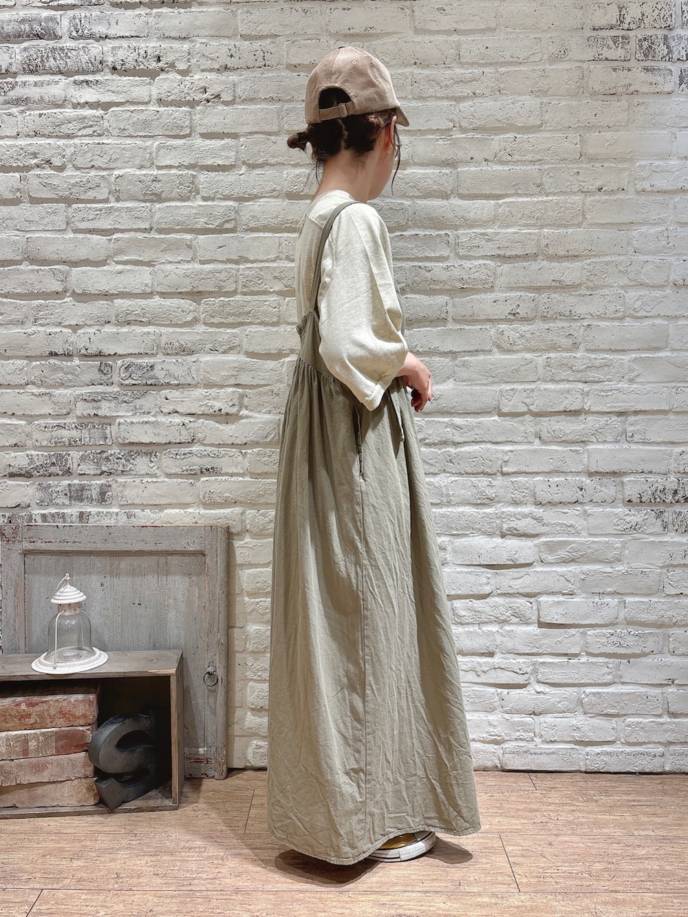 ホワイト系のTシャツ/カットソー、グリーン系のワンピース、ベージュ系のハットを着用したレディースの秋コーディネートの3枚目の写真