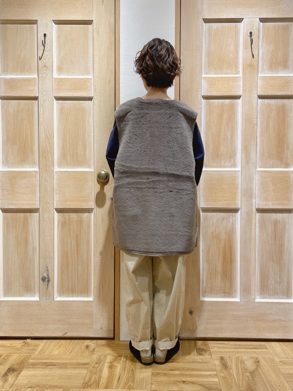 グレー系のベスト、ブラック系のスウェット、ベージュ系のカーゴパンツを着用したレディースの秋コーディネートの3枚目の写真