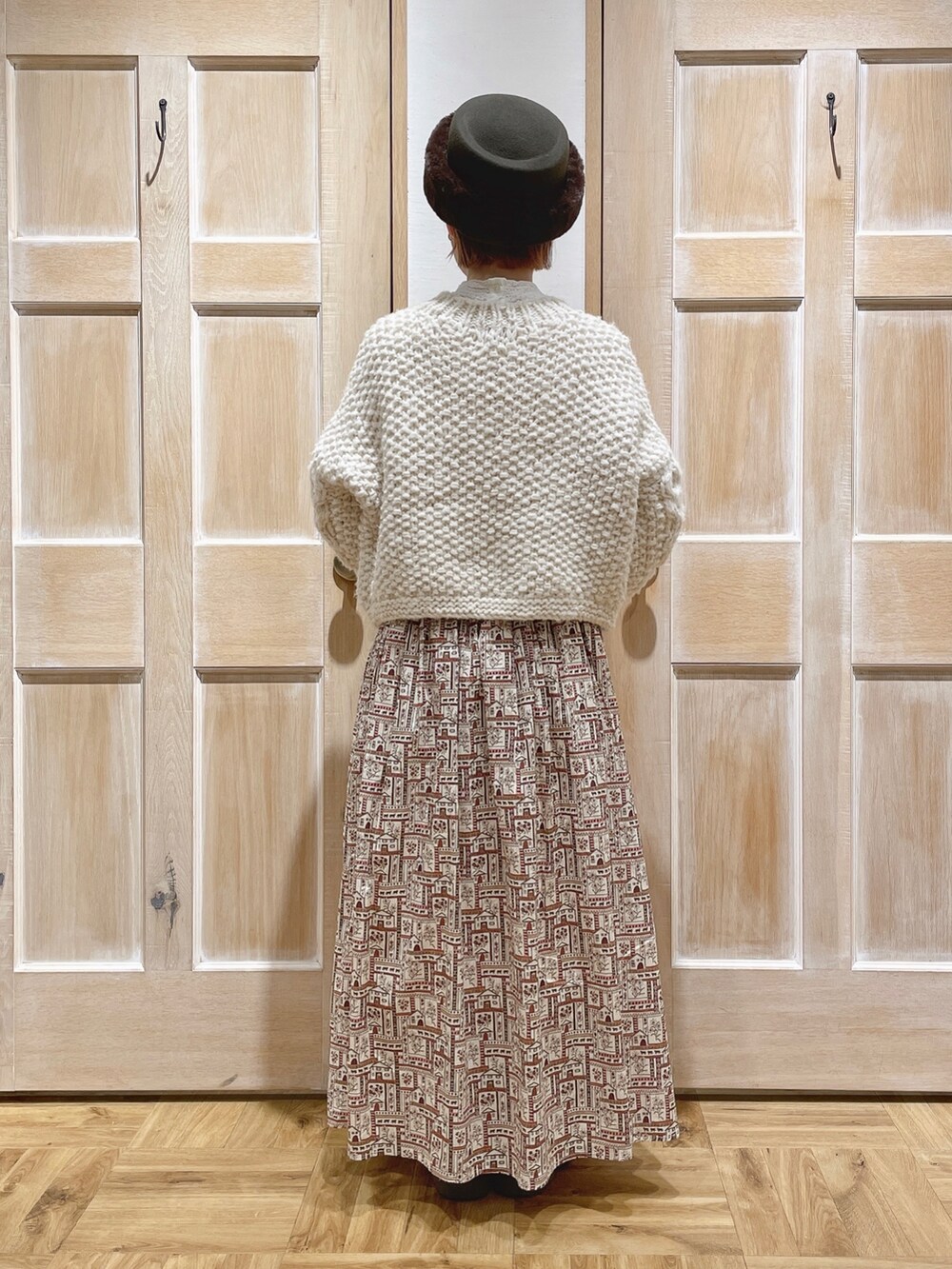 ホワイト系のニット/セーター、レッド系のスカート、ブラウン系のハットを着用したレディースの冬コーディネートの3枚目の写真