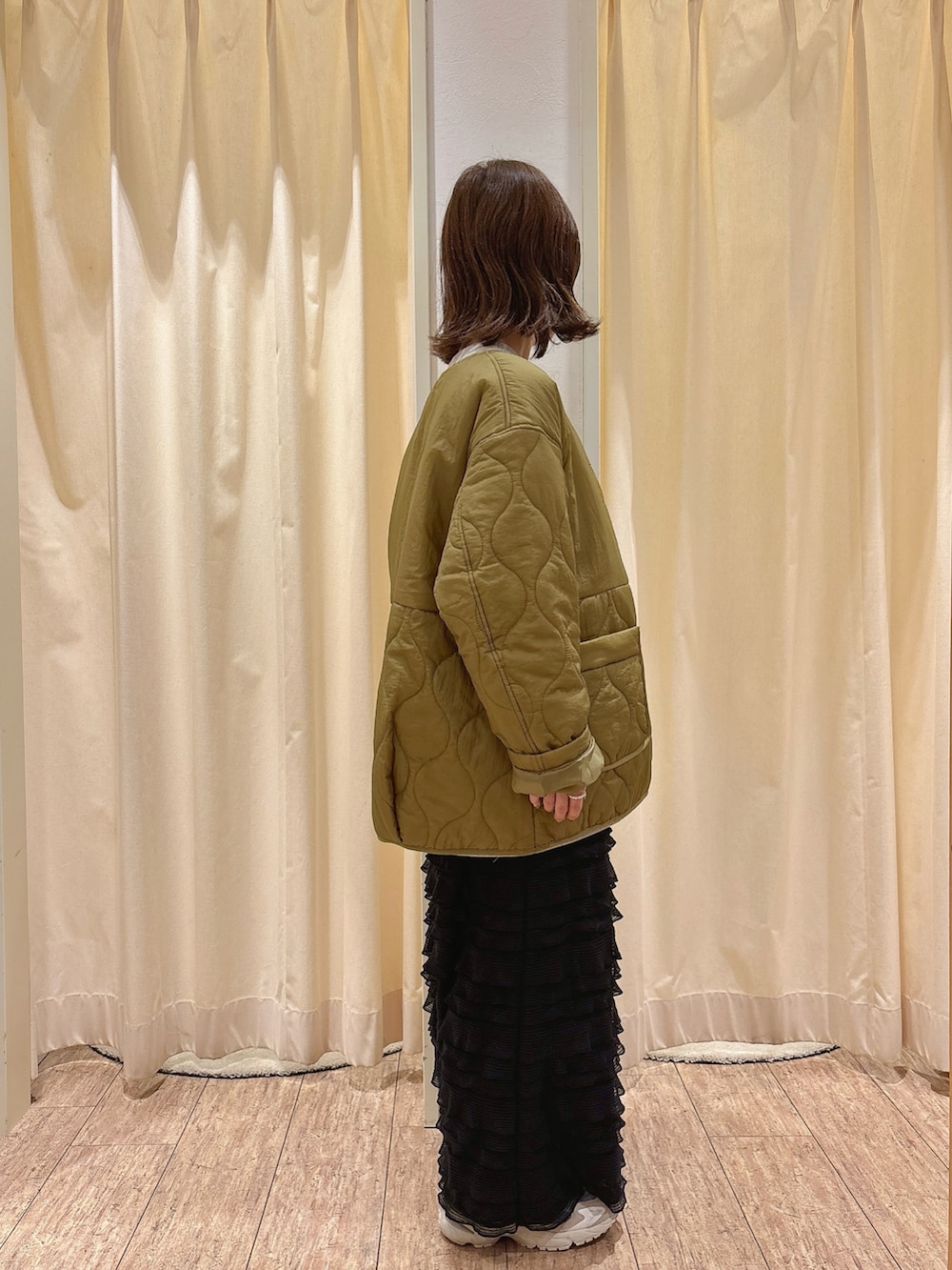 グレー系のTシャツ/カットソー、グリーン系のブルゾン、ブラック系のスカートを着用したレディースの冬コーディネートの2枚目の写真