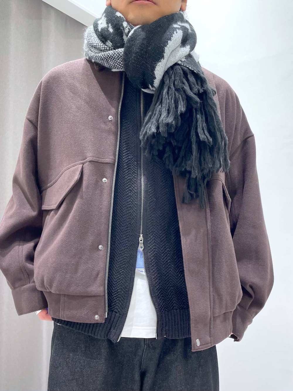 ブラウン系のブルゾン、ブラック系のデニムパンツ、ブラック系のニット/セーターを着用したメンズの秋コーディネートの4枚目の写真