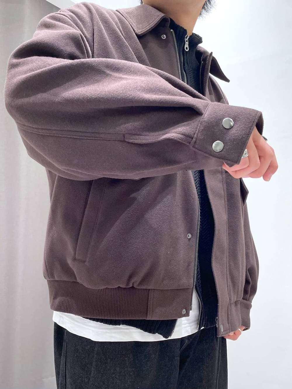 ブラウン系のブルゾン、ブラック系のデニムパンツ、ブラック系のニット/セーターを着用したメンズの秋コーディネートの6枚目の写真