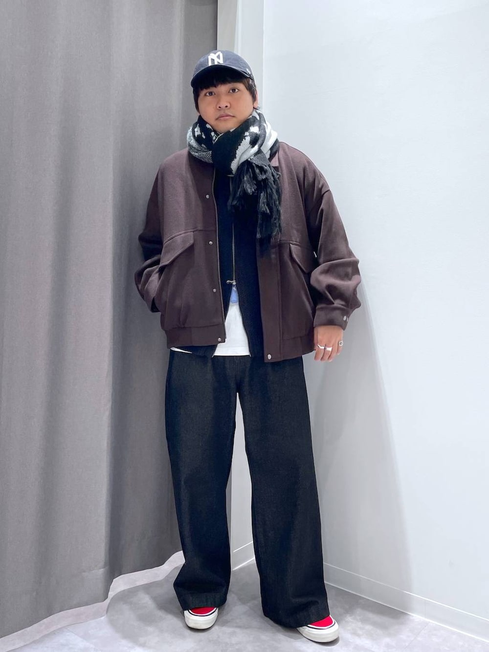 ブラウン系のブルゾン、ブラック系のデニムパンツ、ブラック系のニット/セーターを着用したメンズの秋コーディネートの7枚目の写真