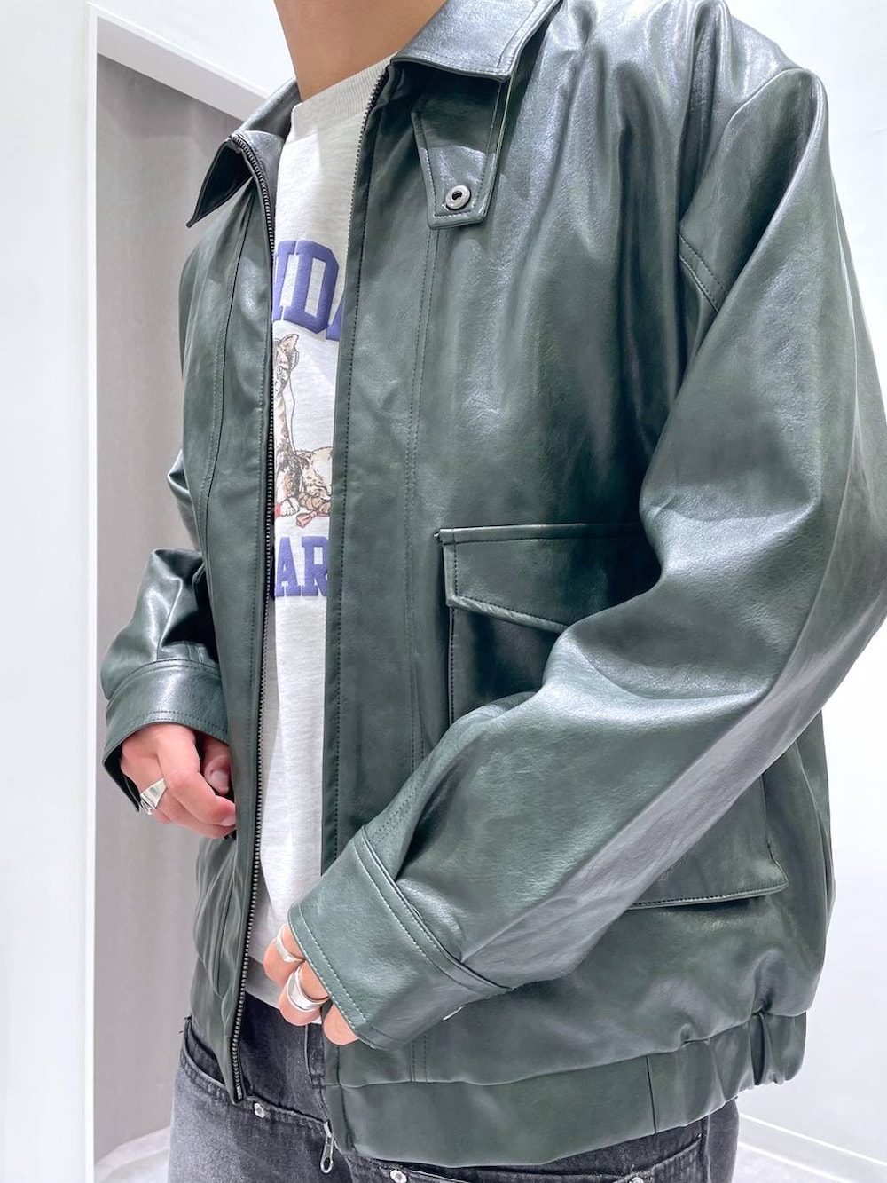 ブラック系のデニムパンツ、グレー系のスウェット、グリーン系のブルゾンを着用したメンズの秋コーディネートの5枚目の写真