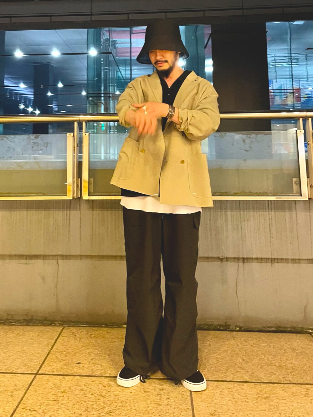 ベージュ系のテーラードジャケット、ブラック系のシャツ/ブラウス、ホワイト系のタンクトップを着用したメンズの春コーディネートの3枚目の写真