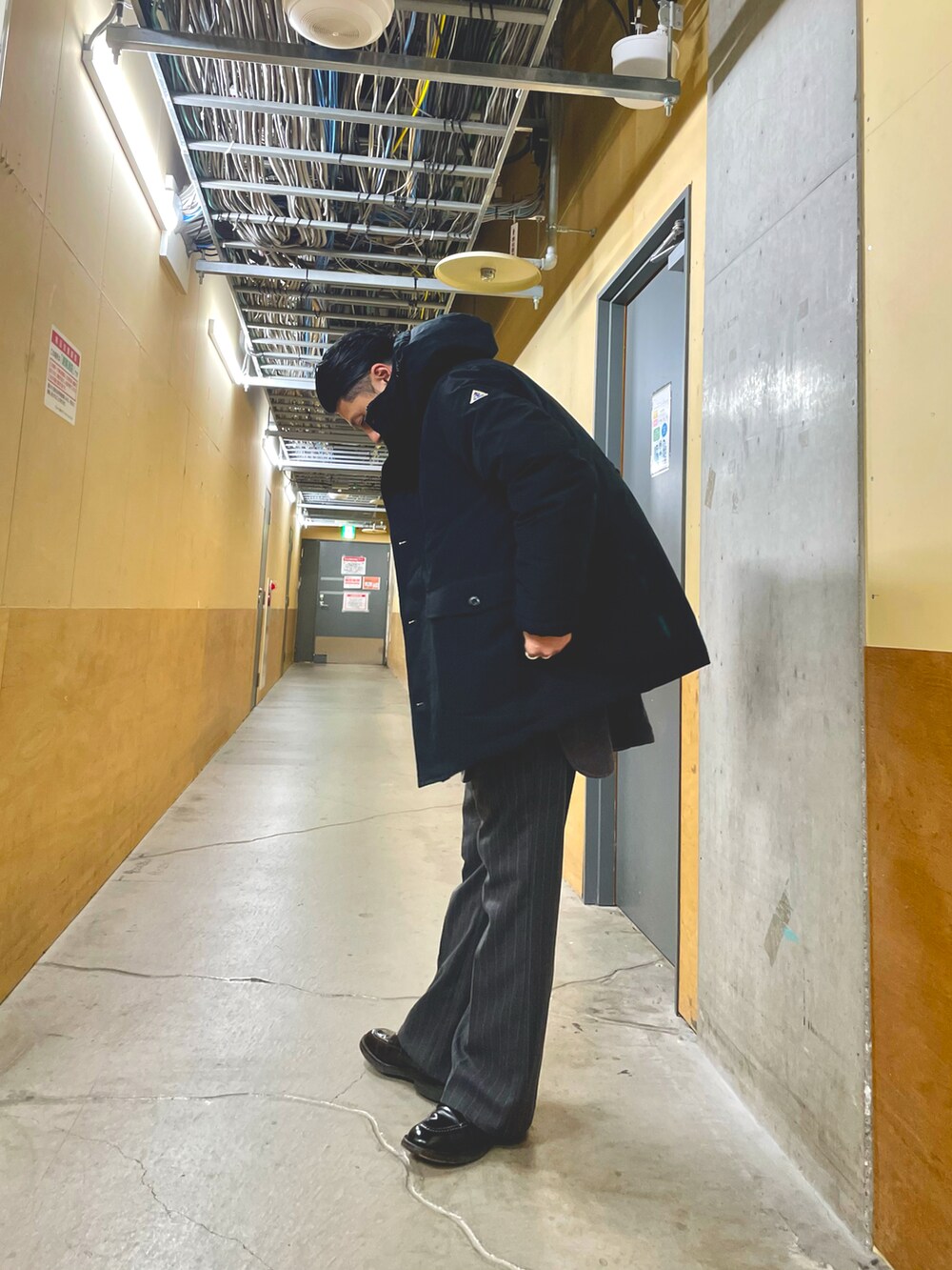 グレー系のその他パンツ、ブラック系のベスト、ブラック系のダウンジャケット/コートを着用したメンズの冬コーディネートの2枚目の写真