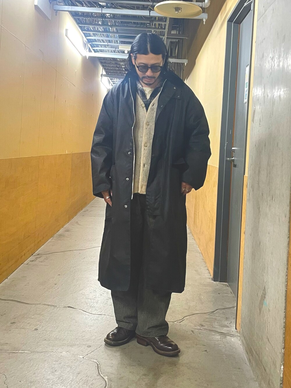 ブラック系のシャツ/ブラウス、ブラック系のトレンチコート、ホワイト系のカーディガン/ボレロを着用したメンズの冬コーディネートの3枚目の写真