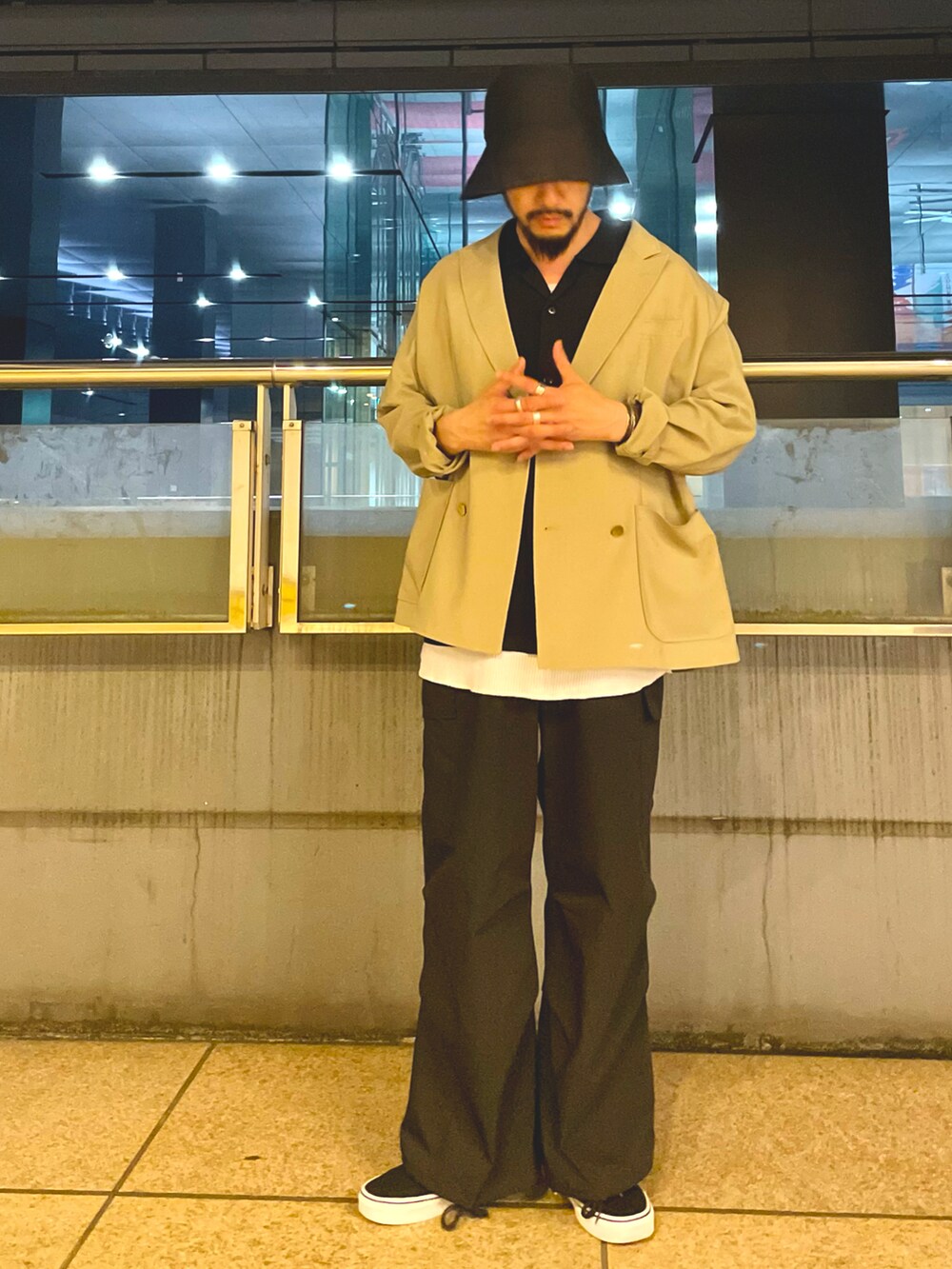 ベージュ系のテーラードジャケット、ブラック系のシャツ/ブラウス、ホワイト系のタンクトップを着用したメンズの春コーディネートの2枚目の写真