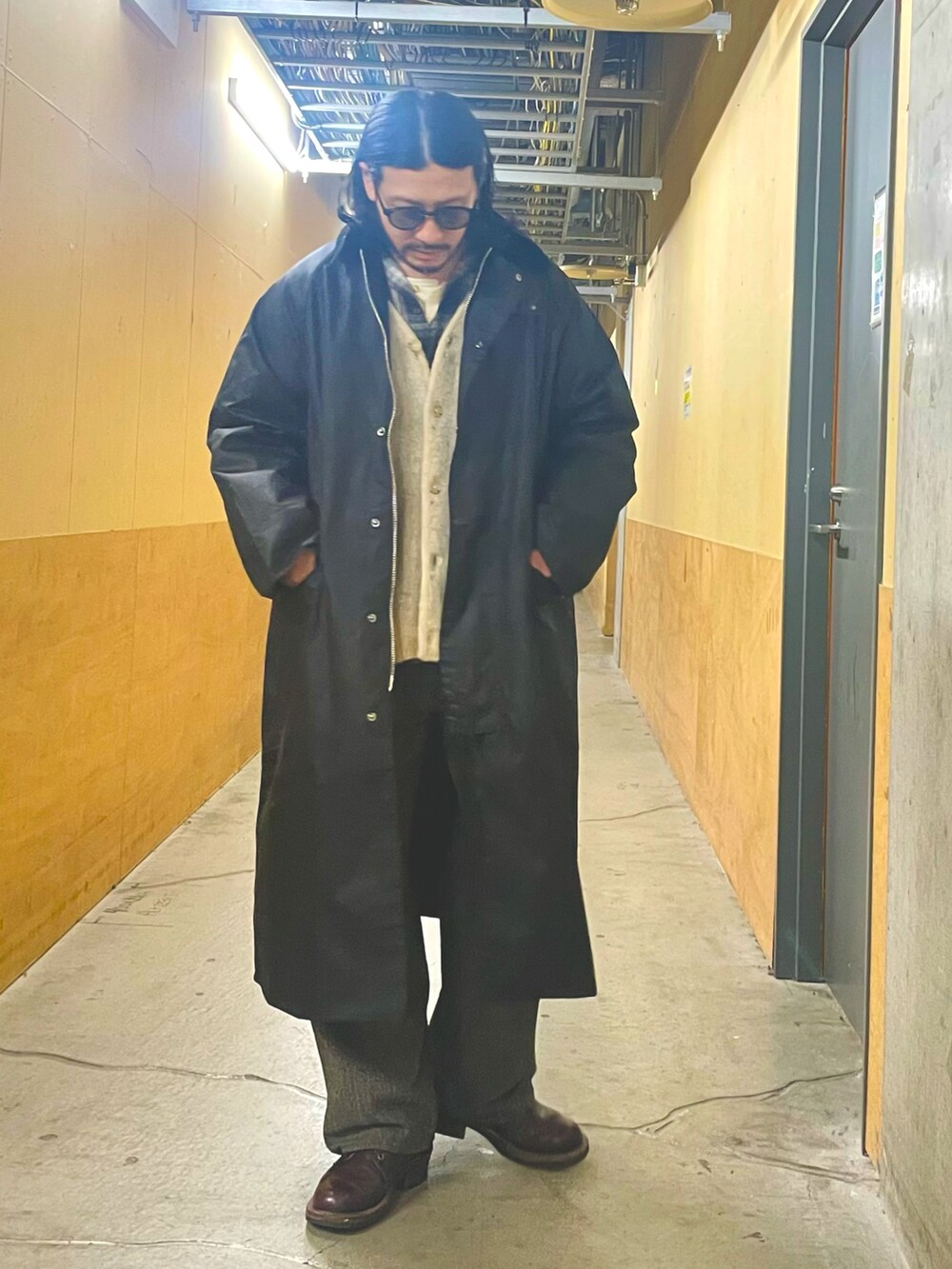 ブラック系のシャツ/ブラウス、ブラック系のトレンチコート、ホワイト系のカーディガン/ボレロを着用したメンズの冬コーディネートの2枚目の写真