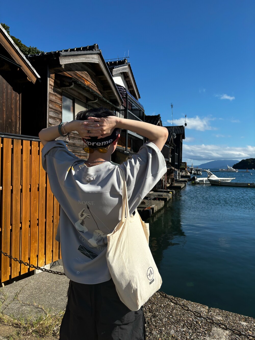 シルバー系のTシャツ/カットソー、ブラック系のカーゴパンツ、ブラック系のスニーカーを着用したメンズの夏コーディネートの3枚目の写真