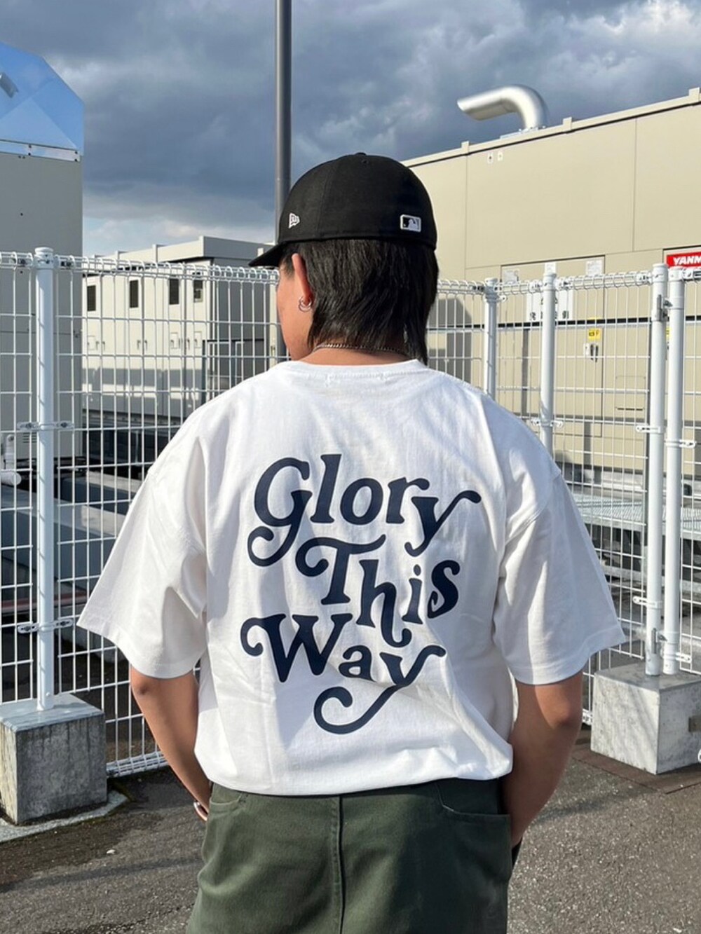 ホワイト系のTシャツ/カットソー、グリーン系のデニムパンツ、ブラック系のブーツを着用したメンズの春コーディネートの2枚目の写真