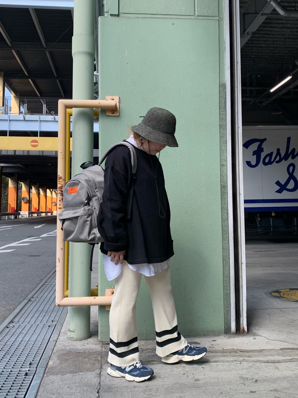 グレー系のバックパック/リュック、ブラック系のニット/セーター、ホワイト系のその他パンツを着用したレディースの春コーディネートの2枚目の写真