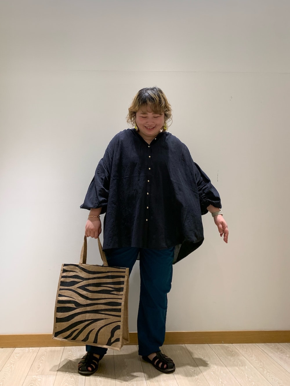 ブラック系のシャツ/ブラウス、グリーン系のその他パンツ、ブラック系のトートバッグを着用したレディースの春コーディネートの2枚目の写真