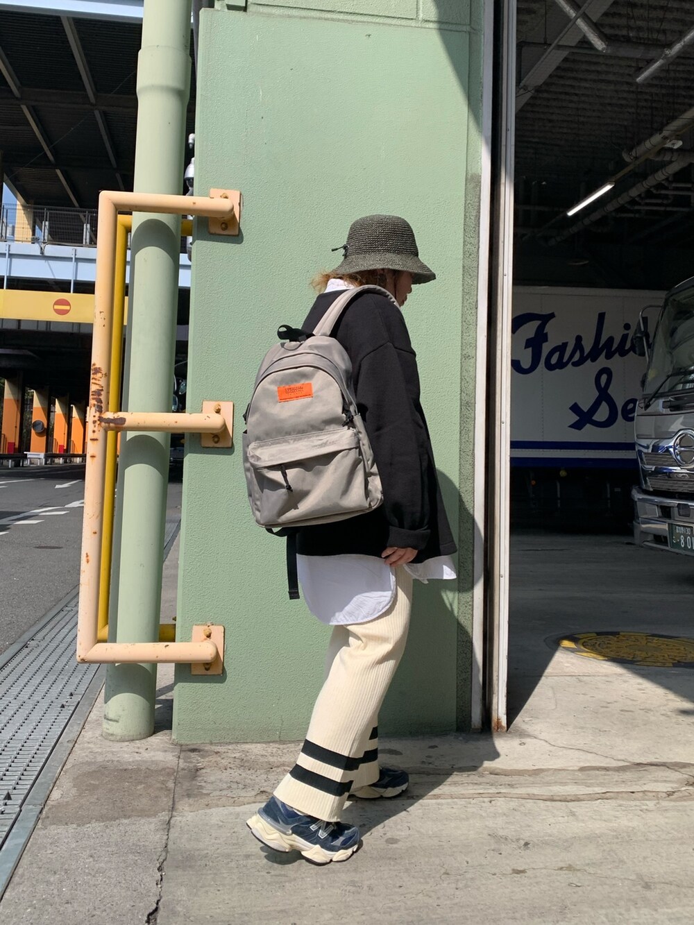 グレー系のバックパック/リュック、ブラック系のニット/セーター、ホワイト系のその他パンツを着用したレディースの春コーディネートの3枚目の写真