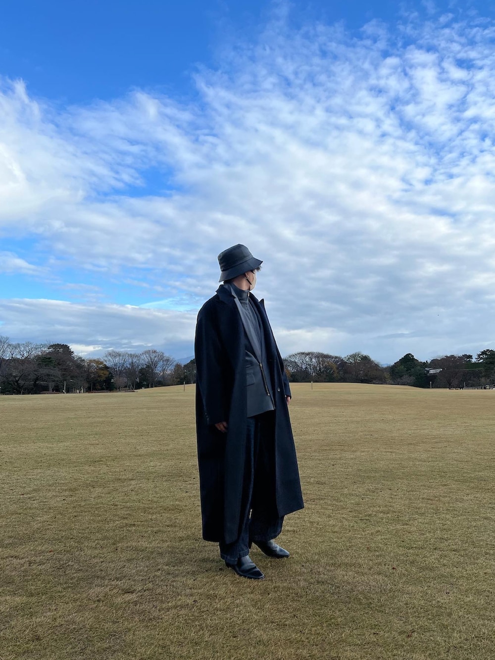 ブラック系のダウンジャケット/コート、ブラック系のドレスシューズ、グレー系のテーラードジャケットを着用したメンズの冬コーディネートの2枚目の写真