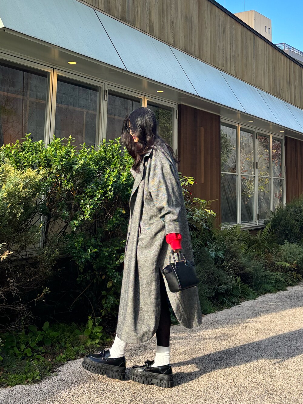 グレー系のジャケット/アウター、ブラック系のローファー、レッド系のスウェットを着用したレディースの冬コーディネートの3枚目の写真