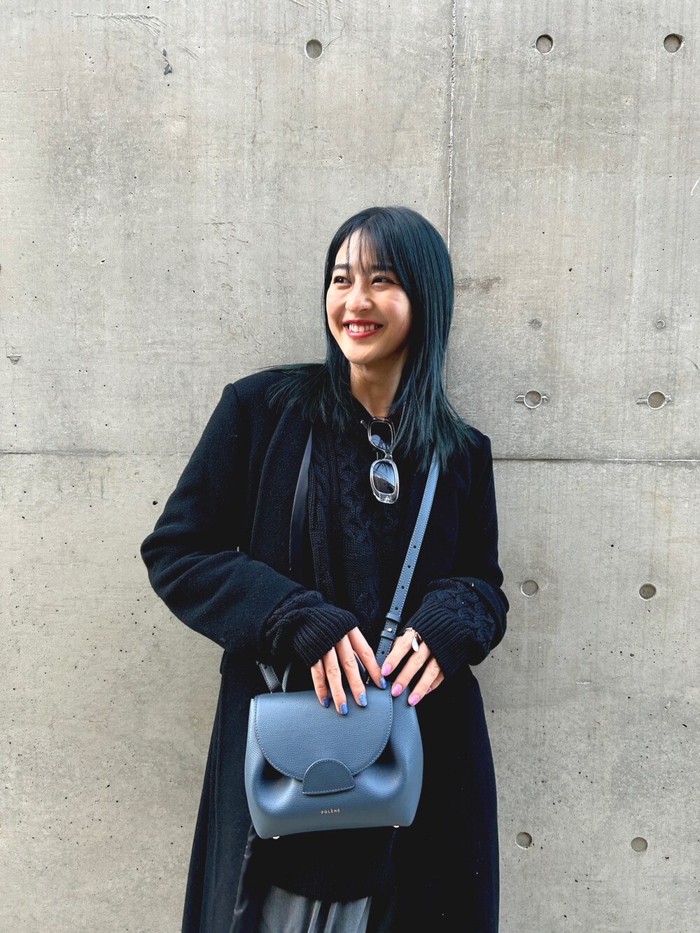 ブラック系のダウンジャケット/コート、ブルー系のショルダーバッグ、グレー系のパンツを着用したレディースの冬コーディネートの3枚目の写真