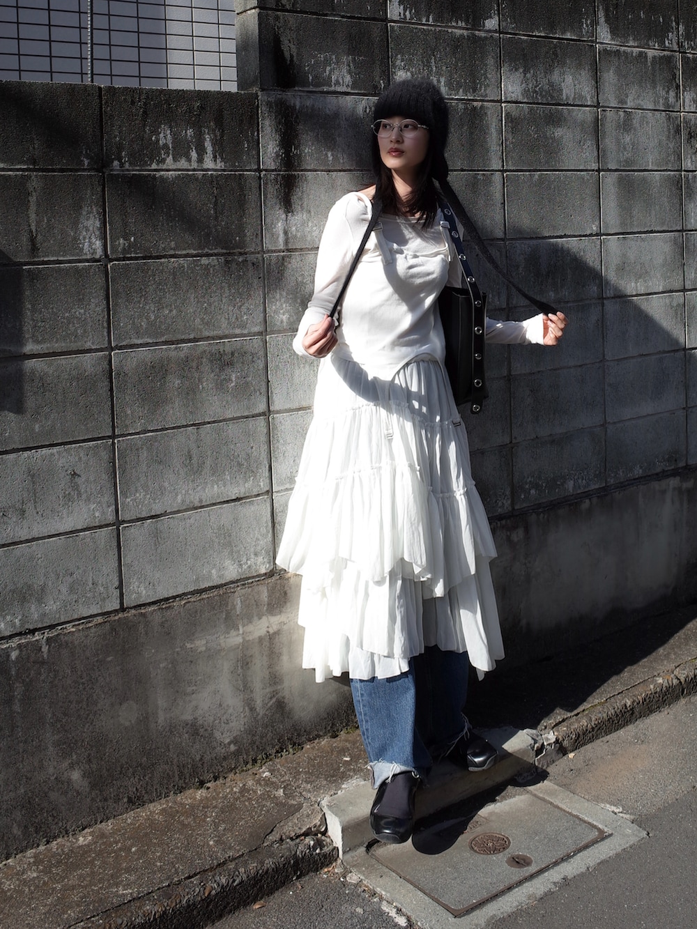 ホワイト系のスカート、ブラック系のバッグを着用したレディースの冬コーディネートの2枚目の写真