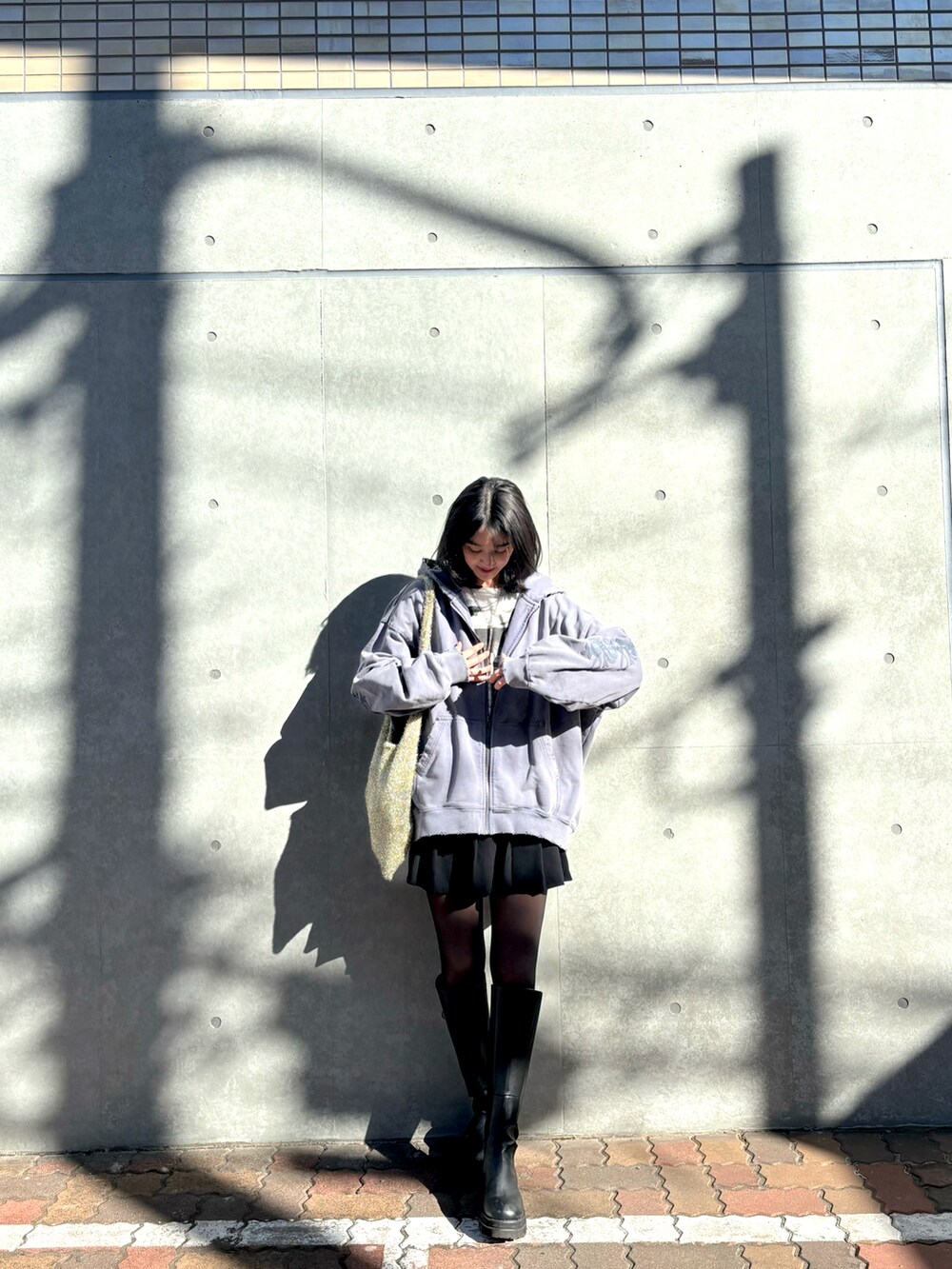 グレー系のパーカー、ブラック系のブーツを着用したレディースの冬コーディネートの2枚目の写真