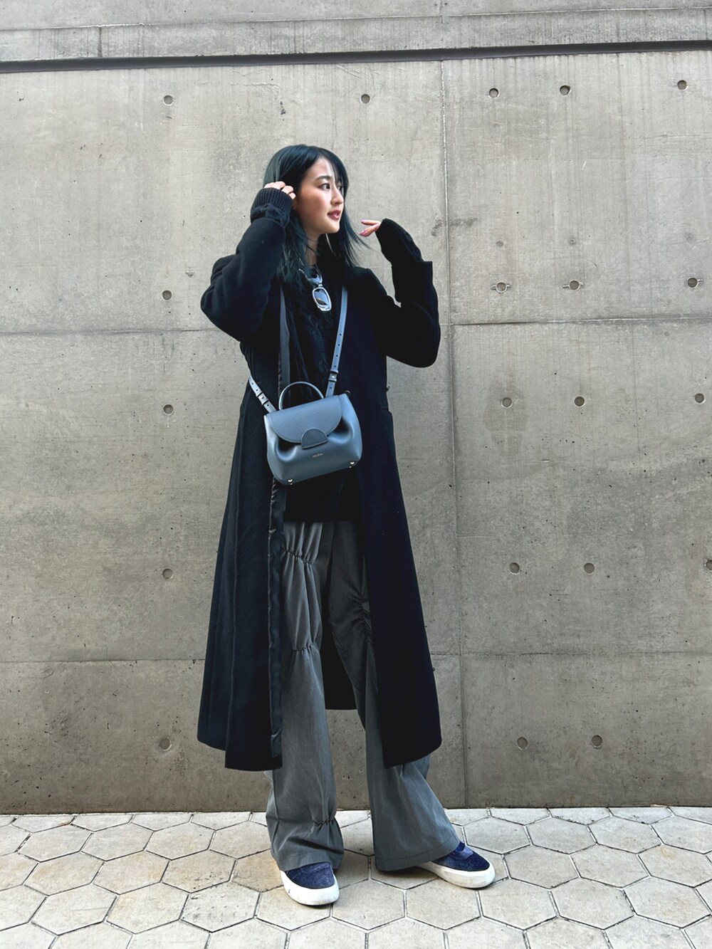 ブラック系のダウンジャケット/コート、ブルー系のショルダーバッグ、グレー系のパンツを着用したレディースの冬コーディネートの2枚目の写真