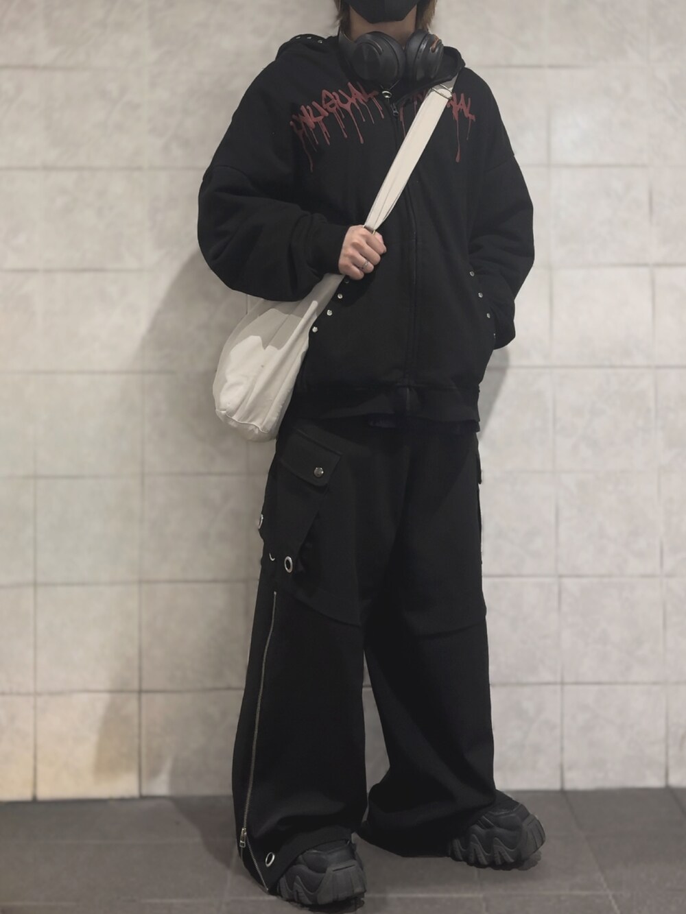 ブルー系のニット/セーター、ブラック系のジャケット/アウター、ブラック系のカーゴパンツを着用したメンズの冬コーディネートの2枚目の写真