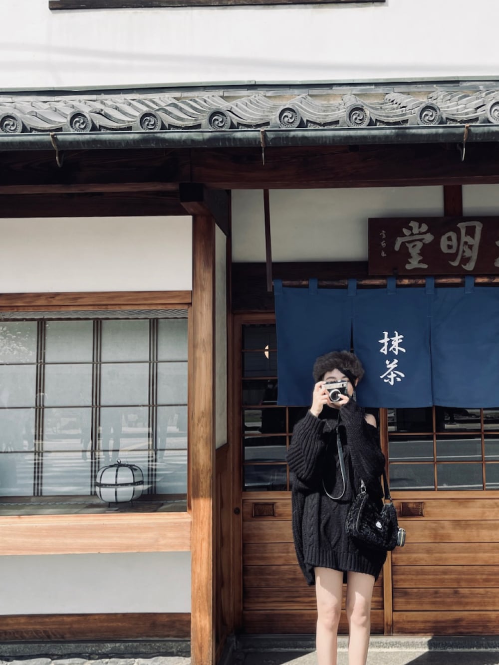 ブラック系のトートバッグ、ブラウン系のシューズ、ブラック系のポーチを着用したレディースの春コーディネートの3枚目の写真