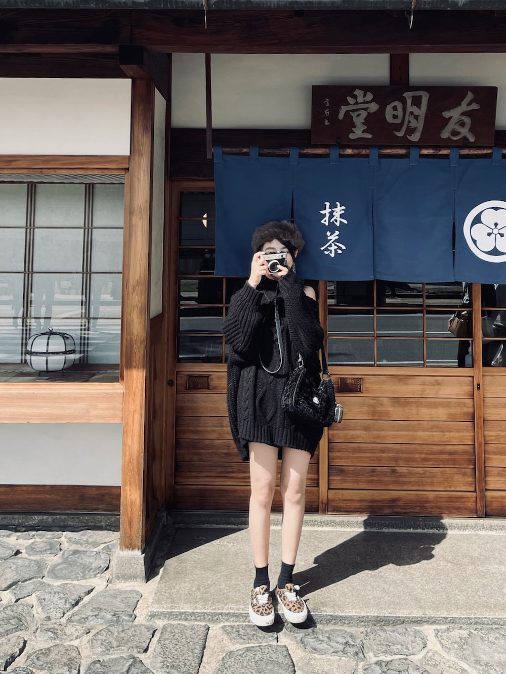 ブラック系のトートバッグ、ブラウン系のシューズ、ブラック系のポーチを着用したレディースの春コーディネートの4枚目の写真