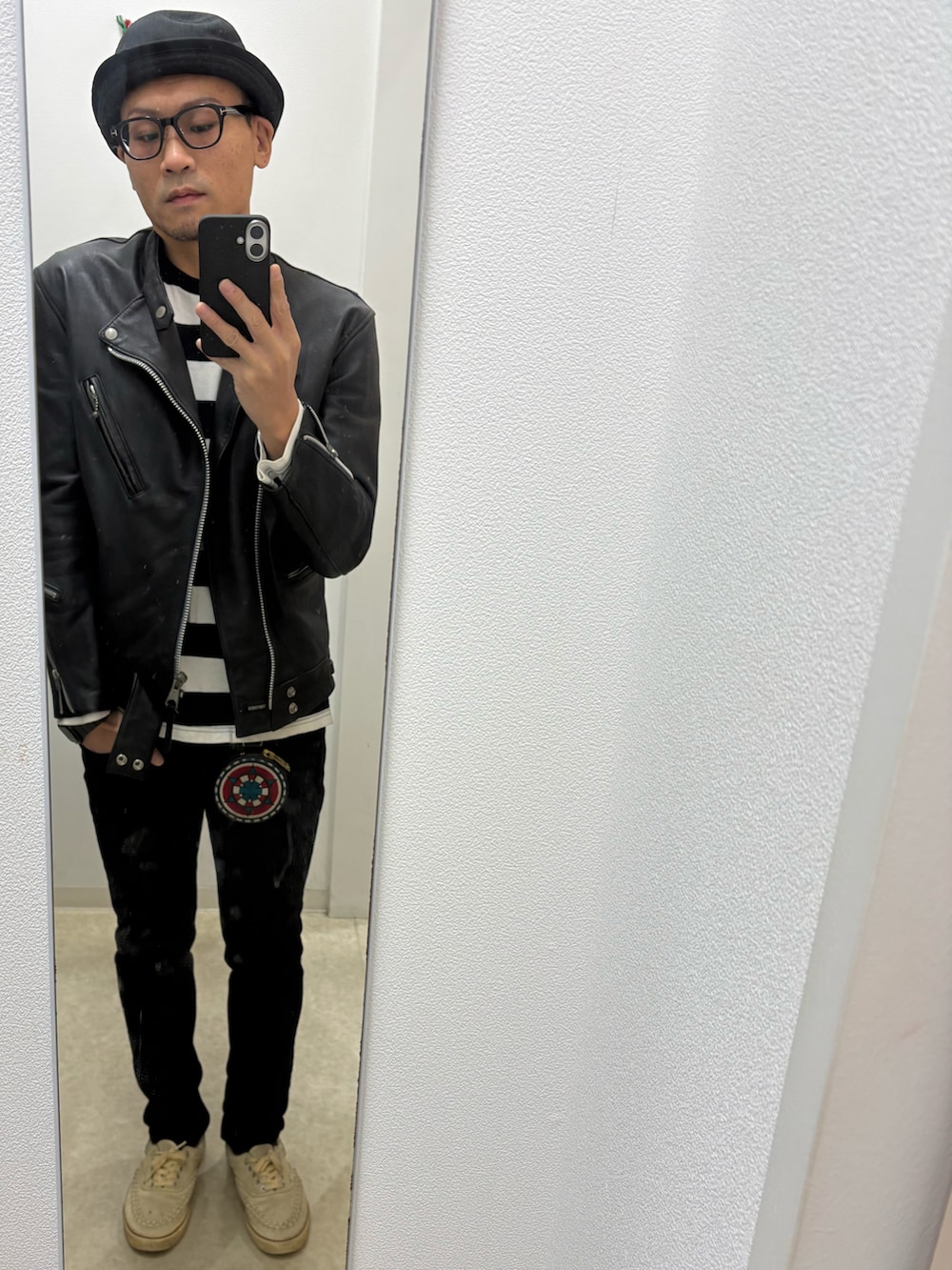 ブラック系のデニムパンツ、ブラック系のTシャツ/カットソー、ブラック系のライダースジャケットを着用したメンズの秋コーディネートの2枚目の写真