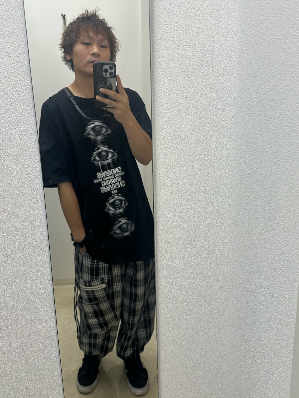 ブラック系のトップス、ブラック系のデニムパンツ、ブラック系のスニーカーを着用したメンズの秋コーディネートの2枚目の写真