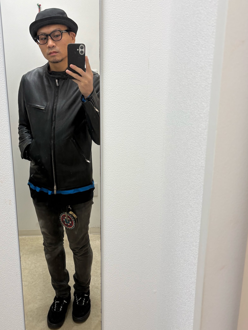 ブラック系のライダースジャケット、ブルー系のTシャツ/カットソー、ブラック系のデニムパンツを着用したメンズの秋コーディネートの2枚目の写真