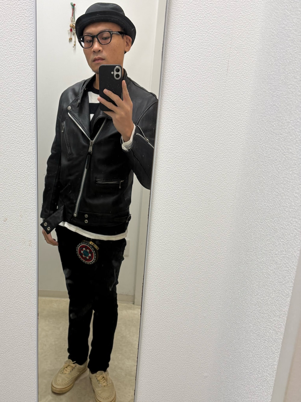 ブラック系のデニムパンツ、ブラック系のTシャツ/カットソー、ブラック系のライダースジャケットを着用したメンズの秋コーディネートの3枚目の写真