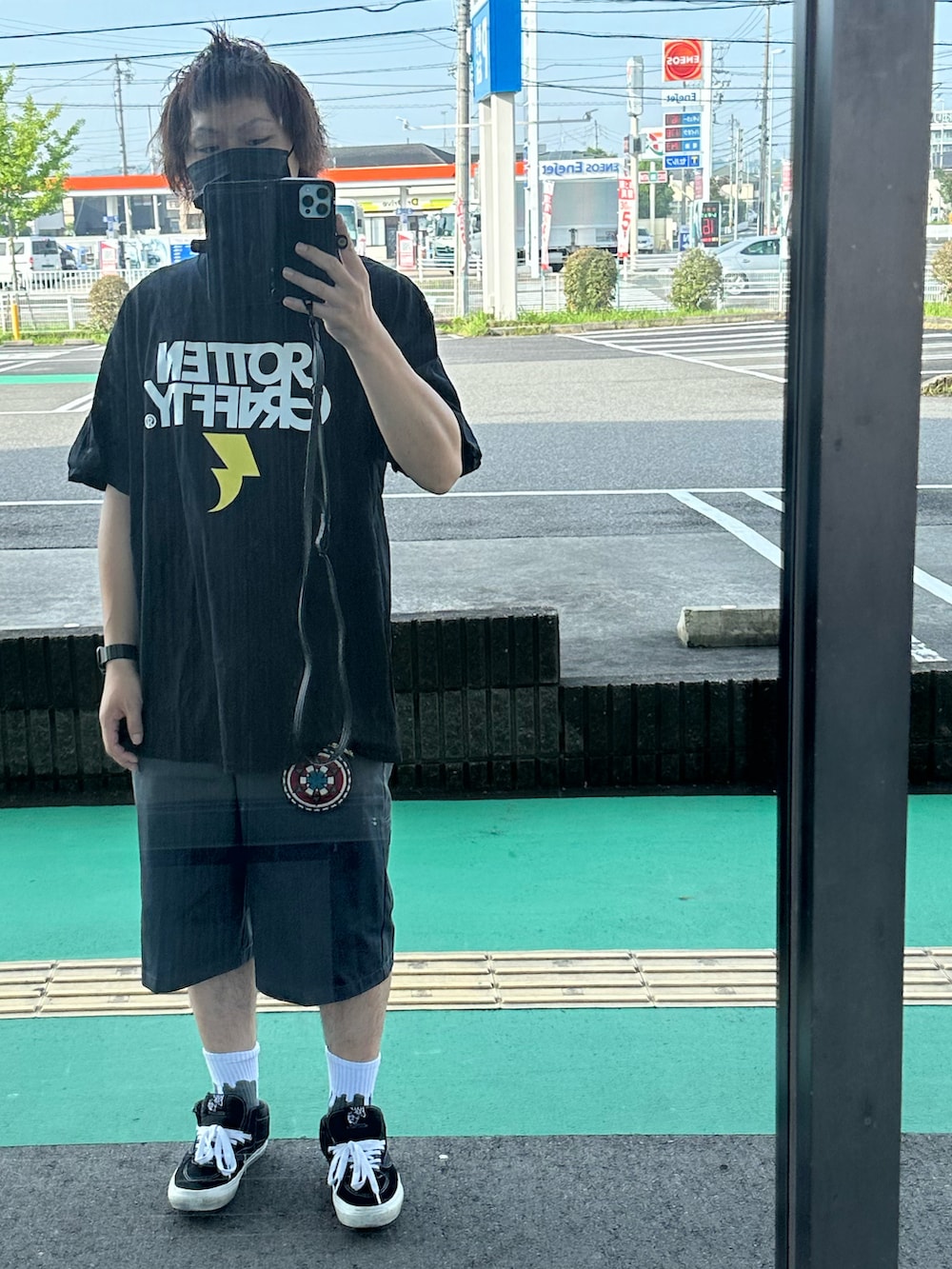 ブラック系のTシャツ/カットソー、グレー系のチノパンツ、ブラック系のスニーカーを着用したメンズの夏コーディネートの2枚目の写真