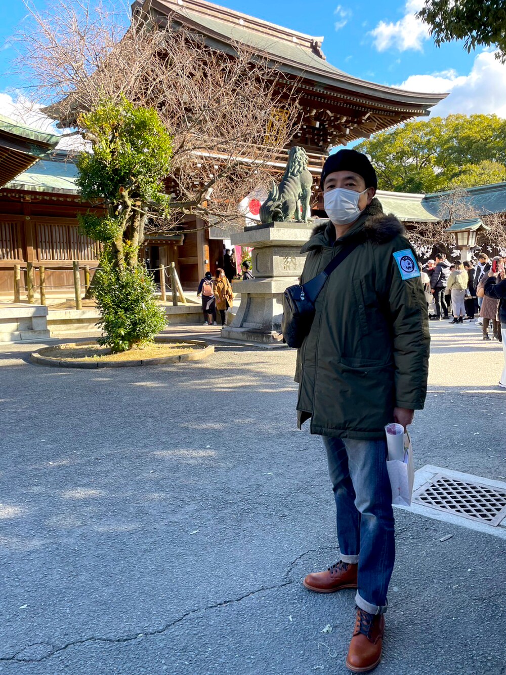 グリーン系のミリタリージャケット、ブルー系のデニムパンツ、ブラウン系のブーツを着用したメンズの冬コーディネートの3枚目の写真