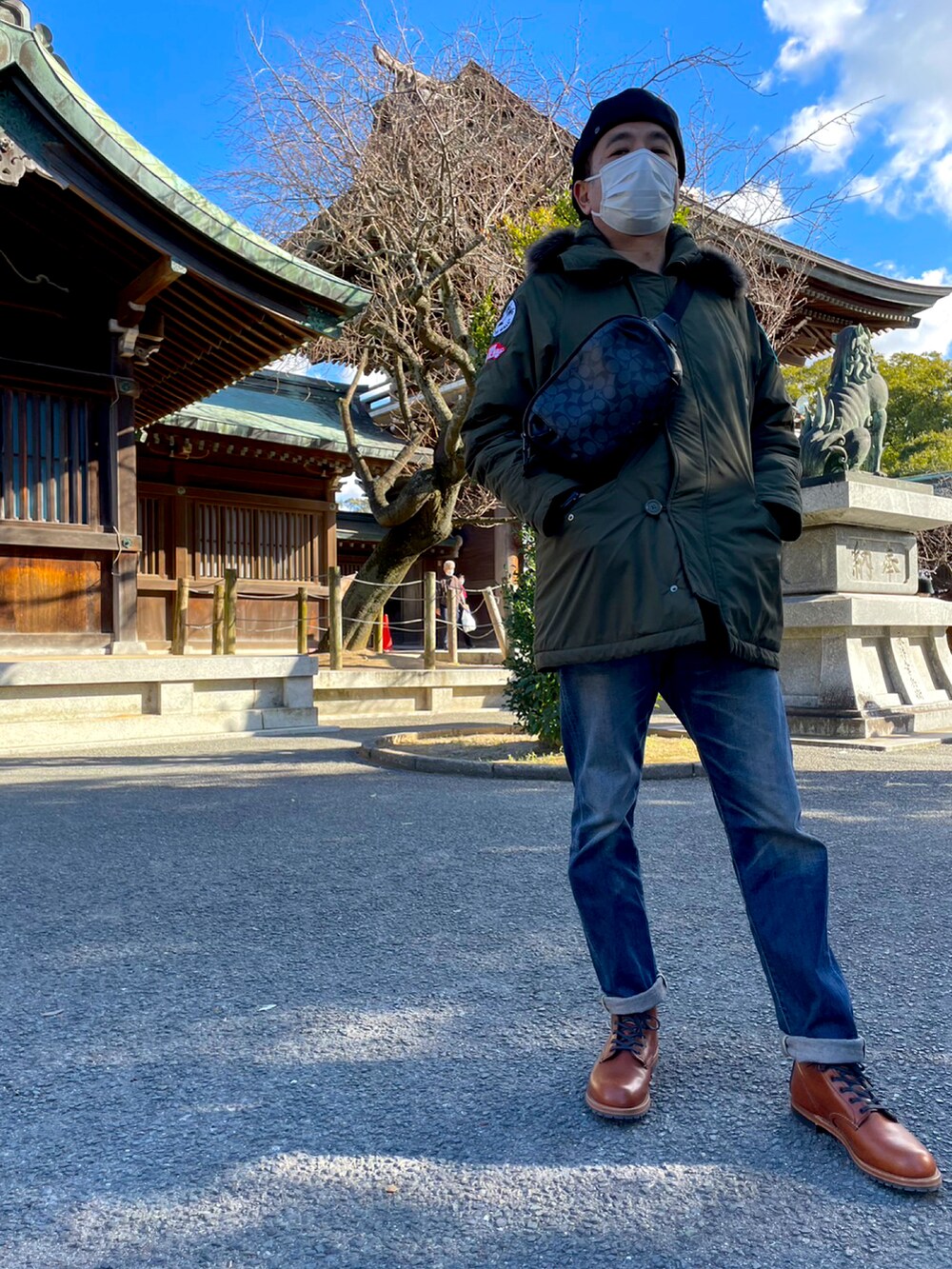 グリーン系のミリタリージャケット、ブルー系のデニムパンツ、ブラウン系のブーツを着用したメンズの冬コーディネートの2枚目の写真