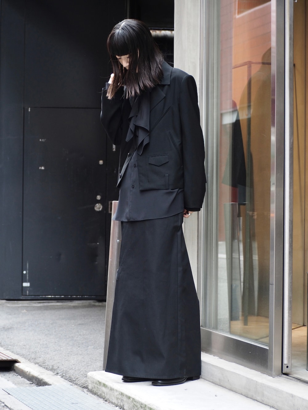 ブラック系のテーラードジャケット、ブラック系のチノパンツ、ブラック系のシャツ/ブラウスを着用したレディースの秋コーディネートの2枚目の写真