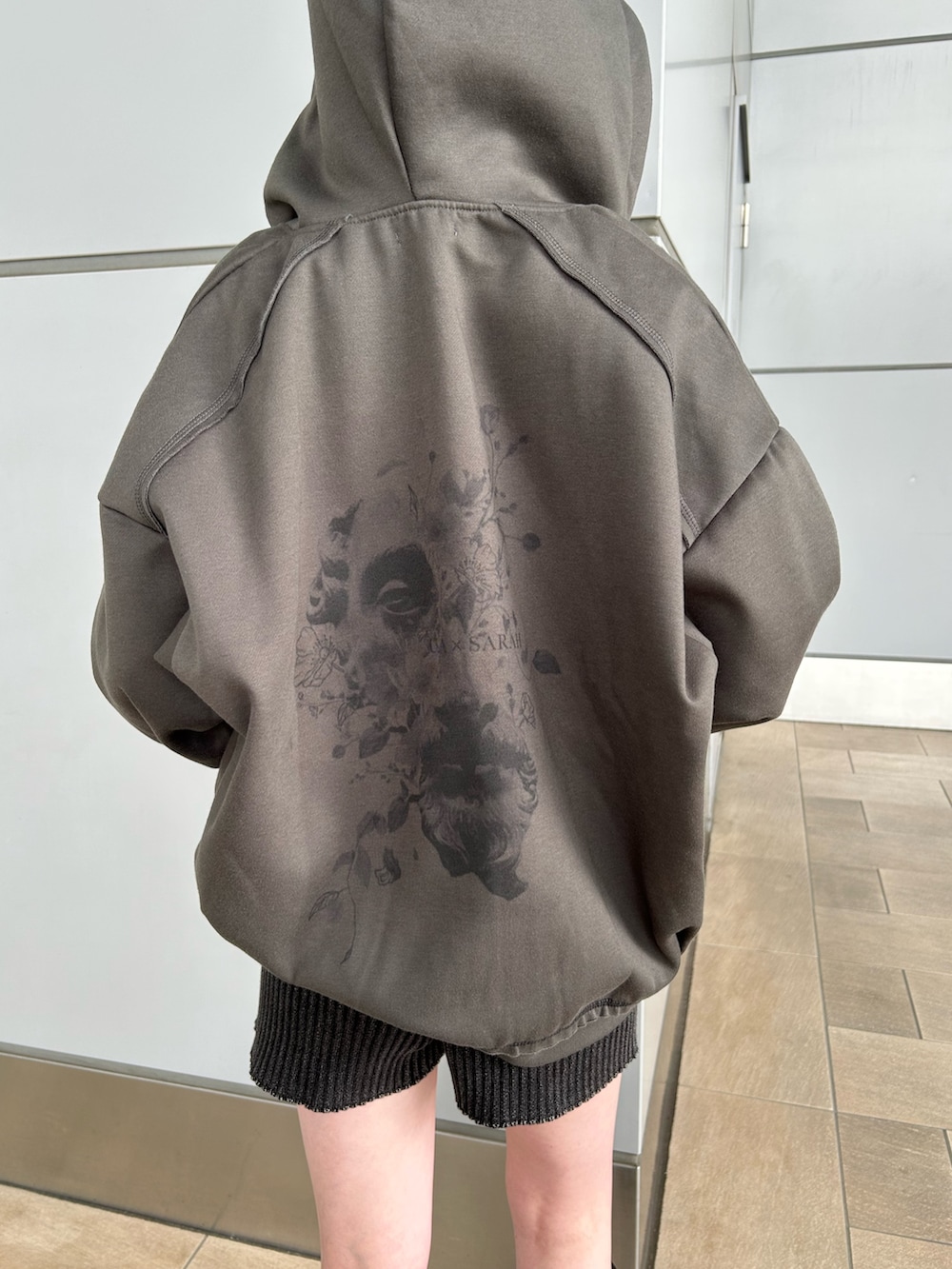 グレー系のパーカー、ブラック系のその他パンツ、ブラック系のブーツを着用したレディースの秋コーディネートの7枚目の写真